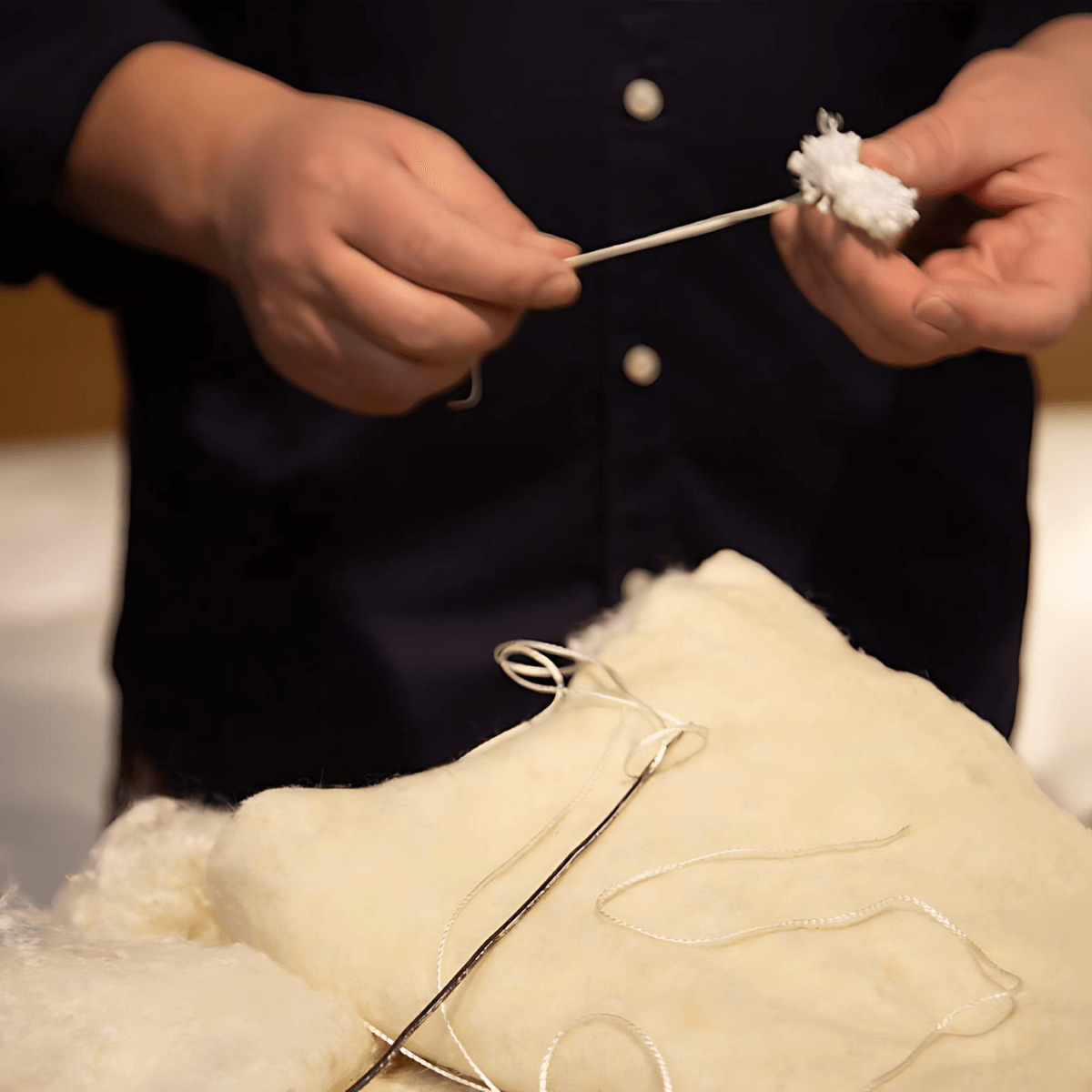 Craftsman hand-making a natural, organic mattress using traditional methods with high-quality fillers.